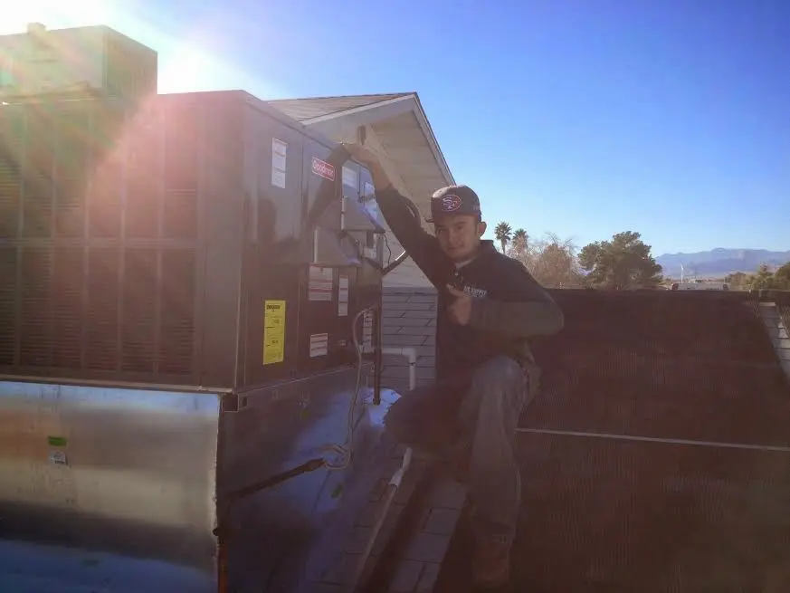 HVAC technician performing HVAC Inspection on a rooftop unit in South Elgin